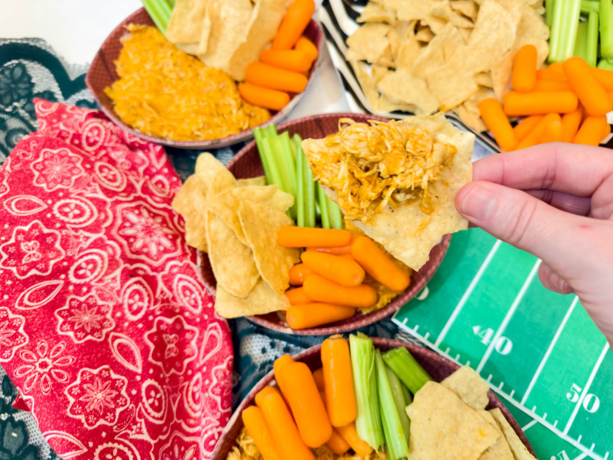 dipping tortilla chips in rotisserie chicken dip