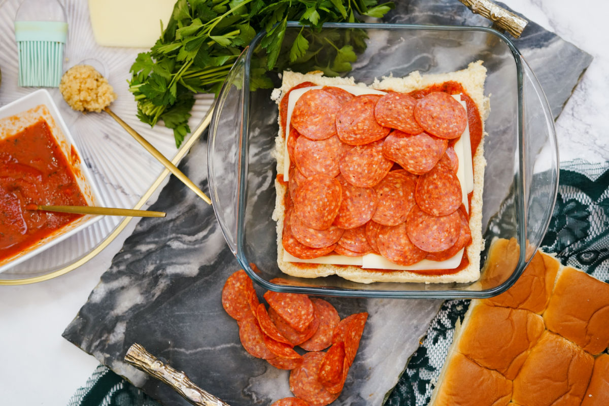 adding cheese and pepperoni to sliders