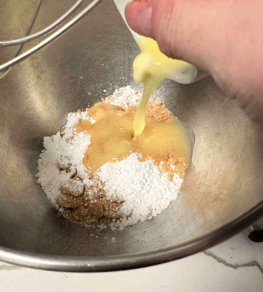 mixing graham cracker crumbs with butter and sugar