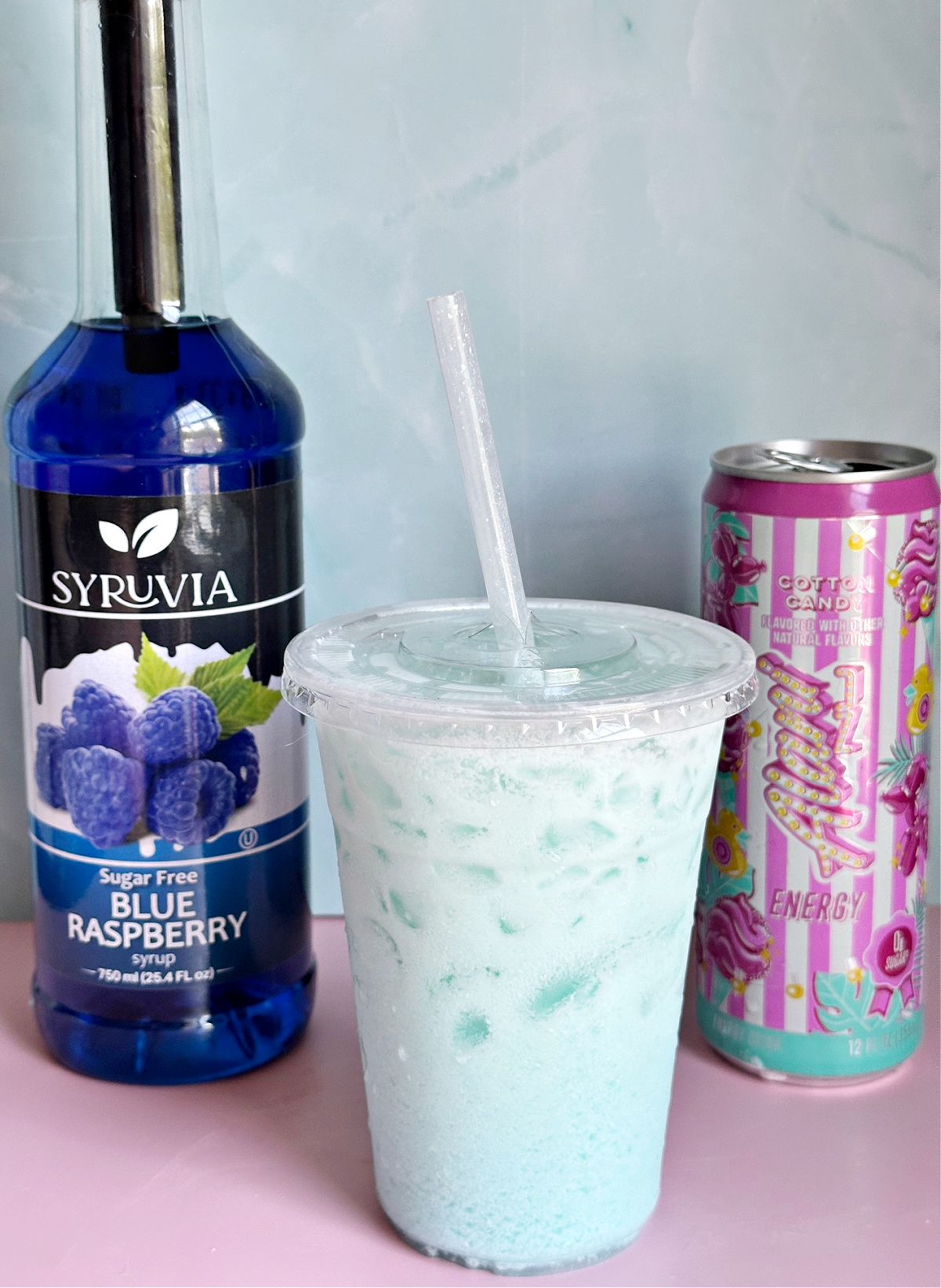 Cotton Candy Dirty Alani Drink in clear cup with blue raspberry