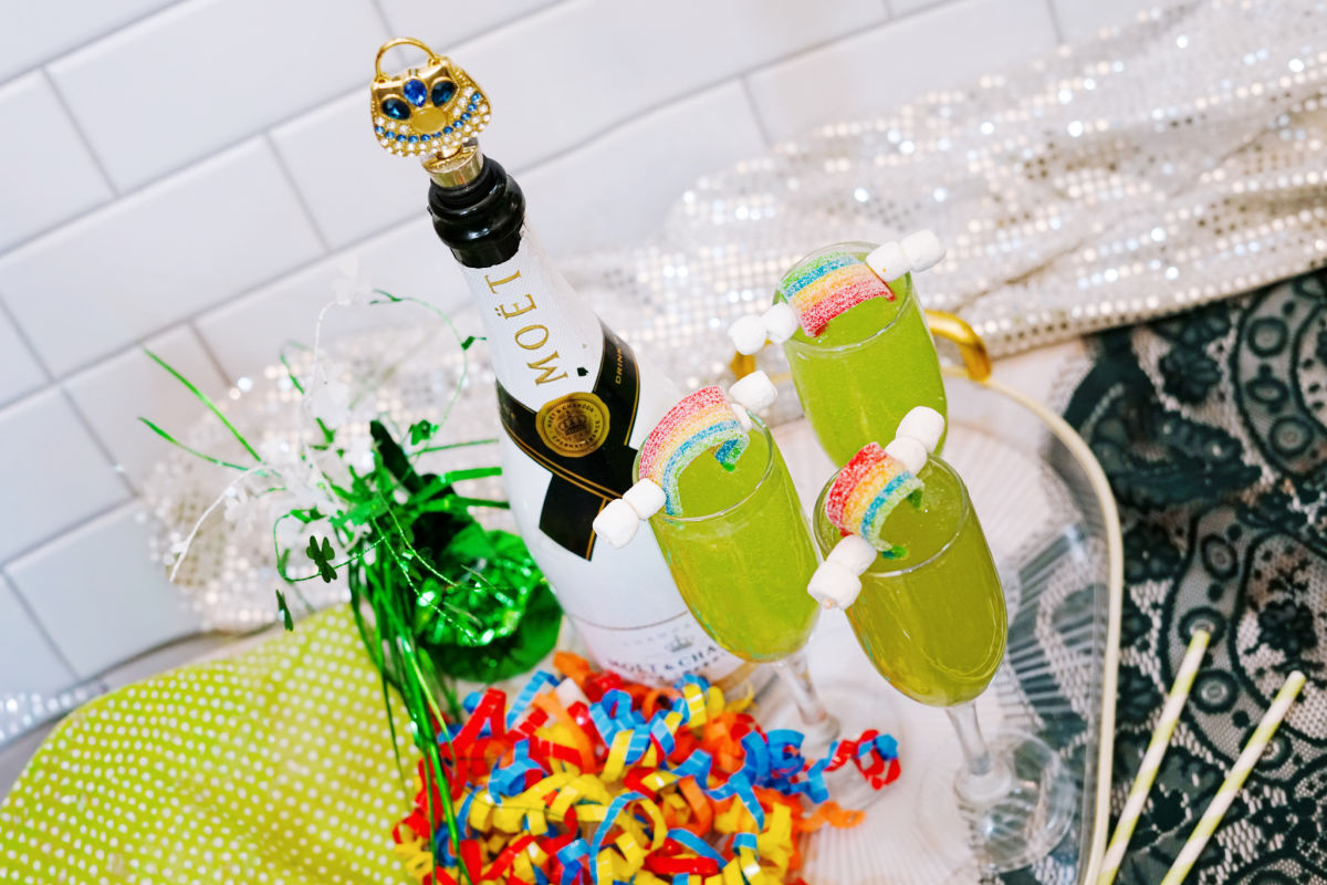 4 St Patrick's Day mimosas on tray with champagne bottle